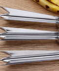 Close-up of two-pack pineapple eye remover and peeler set stainless steel V shape on wooden surface, fruit tool.