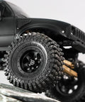 Close-up of M2 Wheel Lock Nuts With CNC Aluminum Cap for 1/24 RC Crawlers, fitted on a black tire, showing full nut coverage.