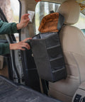 Trasher Vehicle Trash Can For Cars And Trucks, Rugged Modular Utility Bag installed behind car seat with magnetic lid open.