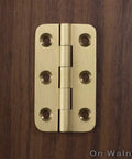 Built Tough 2 Inch Brushed Solid Brass Butt Hinges With Full Mounting Hardware For Heavy Lifting Door Installation Rust Resistant Smooth Swivel Action 4 Pack Set on wooden background.