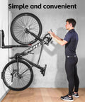 Man using swivel wall bike rack mount for garage storage heavy duty 3mm steel bicycle hanger with adjustable arm fits 24 to 29 inch wheels and tires up to 3.5 inches holds 66 lbs great for road and MTB bikes