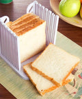 Adjustable Toast Slicer And Bread Cutting Guide For No Fuss Home Bakes Made With Food Grade ABS Plastic Bread Slicer For Even Uniform Slices Foldable Kitchen Tool White with bread slices