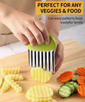 Crinkle cutter with green handle and stainless steel blade cutting potatoes and other vegetables on a wooden board