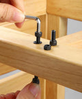 Hand using an Allen wrench on M3 X 50mm Hex Socket Head Cap Screws made from durable carbon steel.