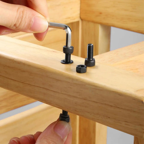 Hand using an Allen wrench on M3 X 50mm Hex Socket Head Cap Screws made from durable carbon steel.
