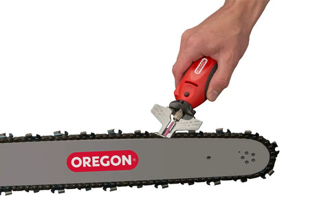 Hand using Sure Sharp 12V Handheld Electric Chainsaw Chain Grinder And Sharpener on a chainsaw blade for maintenance.