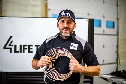 Man holding Copper Nickel Brake Line Coil 1/2 Inch By 25 Foot Non Magnetic Tubing For Automotive Use, Easy Bend and Flare