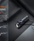 E18R V2.0 1200 Lumen EDC USB C Rechargeable Flashlight connected to USB-C cable near smartphone on table.