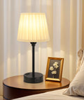 Two Pack Turquoise Bedside Lamps With USB C Port And AC Outlet Charging on a nightstand near a bed, lit with soft glow.