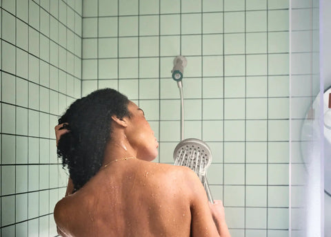 Person using Eco Performance Handheld Shower Head With Magnetix Docking System in bathroom