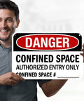 Man holding a warning sign stating 'Danger Confined Space Authorized Entry Only' for safety in restricted areas.