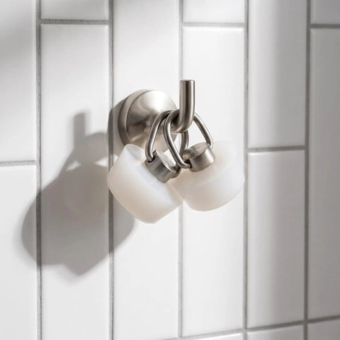 White Drain Stopper with Stainless Steel Ring, Silicone Seal Plug hanging on a wall hook with glossy tiles behind.