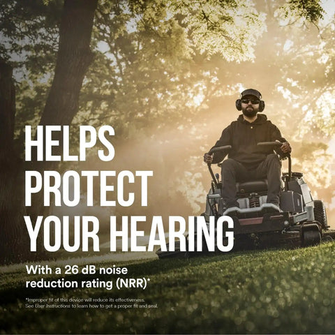 Person using lawnmower wearing WorkTunes Connect Solar Wireless Hearing Protector With Bluetooth, outdoors under sunlight.