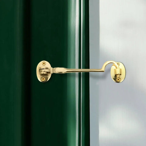 Durable Brass Storage Hook With Swivel Eye Latch For Cabinets And Doors installed on green door and white frame