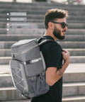 Man carrying Insulated Cooler Backpack With Leakproof Liner, Soft Lunch Ice Bag for 16 Hours, urban background