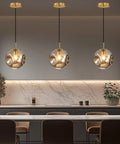 Modern Smoke Gray Glass Globe Pendant Light 3 Pack, 7.87" Hardwired Brass Pendant hanging above a kitchen island.