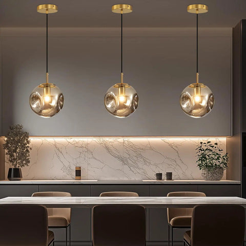Modern Smoke Gray Glass Globe Pendant Light 3 Pack, 7.87" Hardwired Brass Pendant hanging above a kitchen island.
