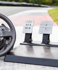 Front view of Thrustmaster T300RS GT steering wheel with three metal pedal plates on a base