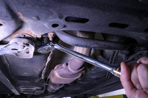 Four Piece Ratchet Set With Flexible Head And 90-Tooth Full Polish Finish For Tight Spots used under a vehicle engine.