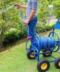 Heavy Duty Metal Hose Reel Cart With Smooth Rolling Wheels For The Backyard Boss Includes Flexible Garden Hoses in use.