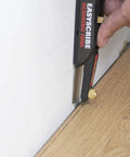 User using EasyScribe scribing tool against a wall for precise measurements with Top Shelf 2H Graphite Lead Refills.