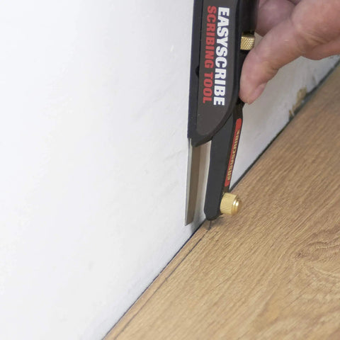 User using EasyScribe scribing tool against a wall for precise measurements with Top Shelf 2H Graphite Lead Refills.