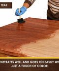 Person using Hella Fast Drying Water Based Wood Stain With A Slick Matte Finish on teak wood table surface.