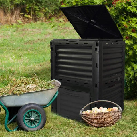 80 Gallon Large Capacity Static Compost Bin With Easy Access Hatch And Efficient Aeration System For Fast Organic Fertilizer Creation For Outdoor Use Black next to a wheelbarrow and basket outdoors