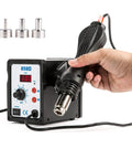 Hand holding 858D SMD Rework Station With Hot Air Gun 700W Soldering Desoldering Kit LED Digital Temperature Display