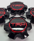 Four Toyota Tacoma TRD Pro Center Cap Set Genuine OE OEM Hub Cap Replacement laid out on a white surface.