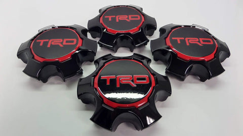 Four Toyota Tacoma TRD Pro Center Cap Set Genuine OE OEM Hub Cap Replacement laid out on a white surface.
