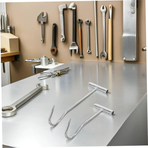 Heavy Duty T Handle Manhole Cover Hooks For Sewer And Septic Tanks Hella Tough Metal Lifters on a workbench, tools in background.