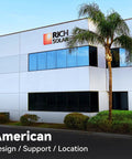 Exterior view of Rich Solar building featuring modern design and palm trees, reflecting off large windows.