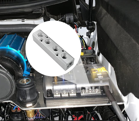 Four Way Pneumatic Manifold Aluminum Alloy Air Distribution Block next to an engine bay, showcasing G1/2 inlet and G1/4 outlets.