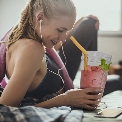 Woman using 2 Pack 24 Oz Blender Cups With Lids And Cup Brush For Auto IQ Blenders, enjoying smoothie on sofa, BPA-free