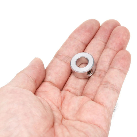 Hand holding a Four Piece Set Screw Aluminum Shaft Collar for Three Eighths Inch Bore, Three Quarters Inch OD, and 3/8 inch thick.