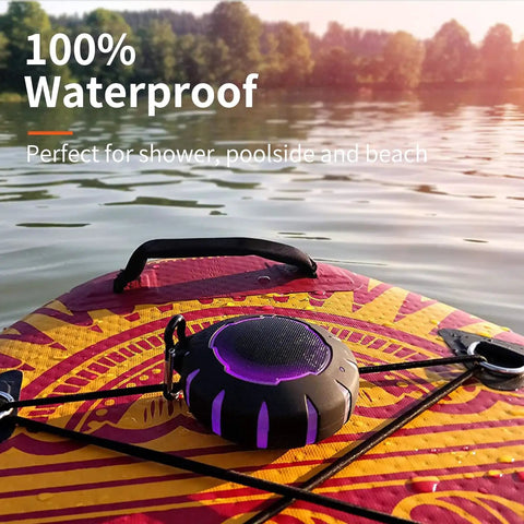 Waterproof Shower Bluetooth Speaker With IPX7 Rating on a paddleboard, showcasing its ultra portable carabiner clip and LED lights.