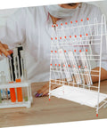 Built Tough White Metal Laboratory Bottle Drying Rack With Thirty Two Pegs For Test Tubes And Glassware utilized for drying glassware.