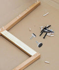 Adjustable M10 Furniture Leveling Feet Set With ABS And Iron Inserts 30 Pack displayed with wooden frame assembly tools