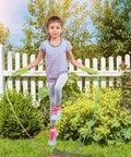Girl playing with Rainbow Jump Rope Set For Kids, 10 Durable Nylon Skipping Ropes, in garden setting, 7.2 feet each