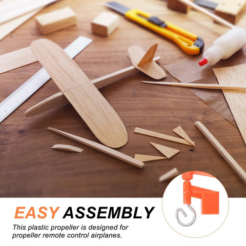 Wooden model airplane kit parts on table with text about easy assembly propeller design