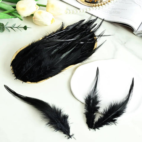 Black Saddle Hackle Rooster Feathers Bulk 200 Pcs 5-7 Inch 12-17 Cm displayed on a table for DIY crafts.