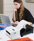 Real Deal Label Roll Organizer Desk Stand For Thermal Printers And Fan Fold Stickers Rack near a laptop in an office setup.