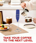 Handheld Milk Frother 14,000 RPM Drink Mixer Wand With Stand next to coffee cup and dessert on table.