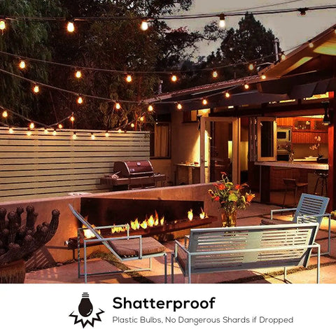51Ft Outdoor Shatterproof LED String Lights With 18 Dimmable Bulbs illuminating a backyard patio with seating and a fire pit at night