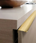 Edge Finger Pulls For Cabinets And Concealed Drawers, Aluminum Long Handle Hardware In Brushed Brass Finish, mounted on drawer.