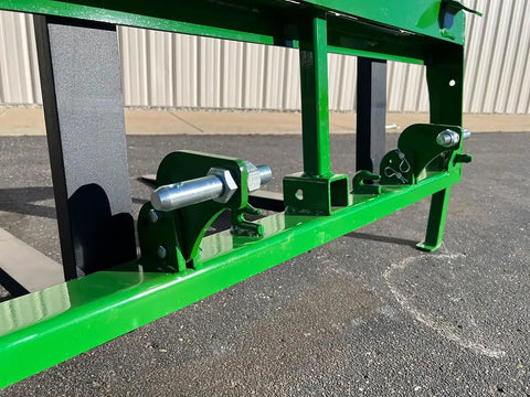 Close-up of No Hassle Dual Mount Tractor Pallet Forks for Front Loader with secure mounts and bright green finish.