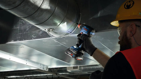 Worker using Two In One Cordless Impact Driver And Wrench 18V Connected Ready For One Fourth Inch And One Half Inch Bits And Sockets