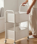 Rock Solid Two Tier Rolling Storage Cart With No Sweat Mobility And Compact Perforated Metal Baskets Ideal For Living Rooms Offices And Daily Grind featuring a person using the cart.