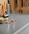 Heavy Duty Adjustable Leveling Feet With Swivel Bottoms And Thick Rubber Non Slip Grip For Shop Tables Tough Carbon Steel Frame displayed on a workbench.